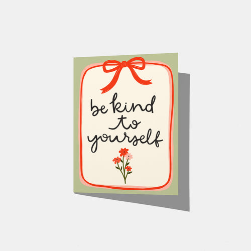 A mockup of a greeting card with the phrase 'be kind to yourself' in black script on a white background, framed by a red border, a red bow illustration at the top, and small red flowers at the bottom, with a sage green border.