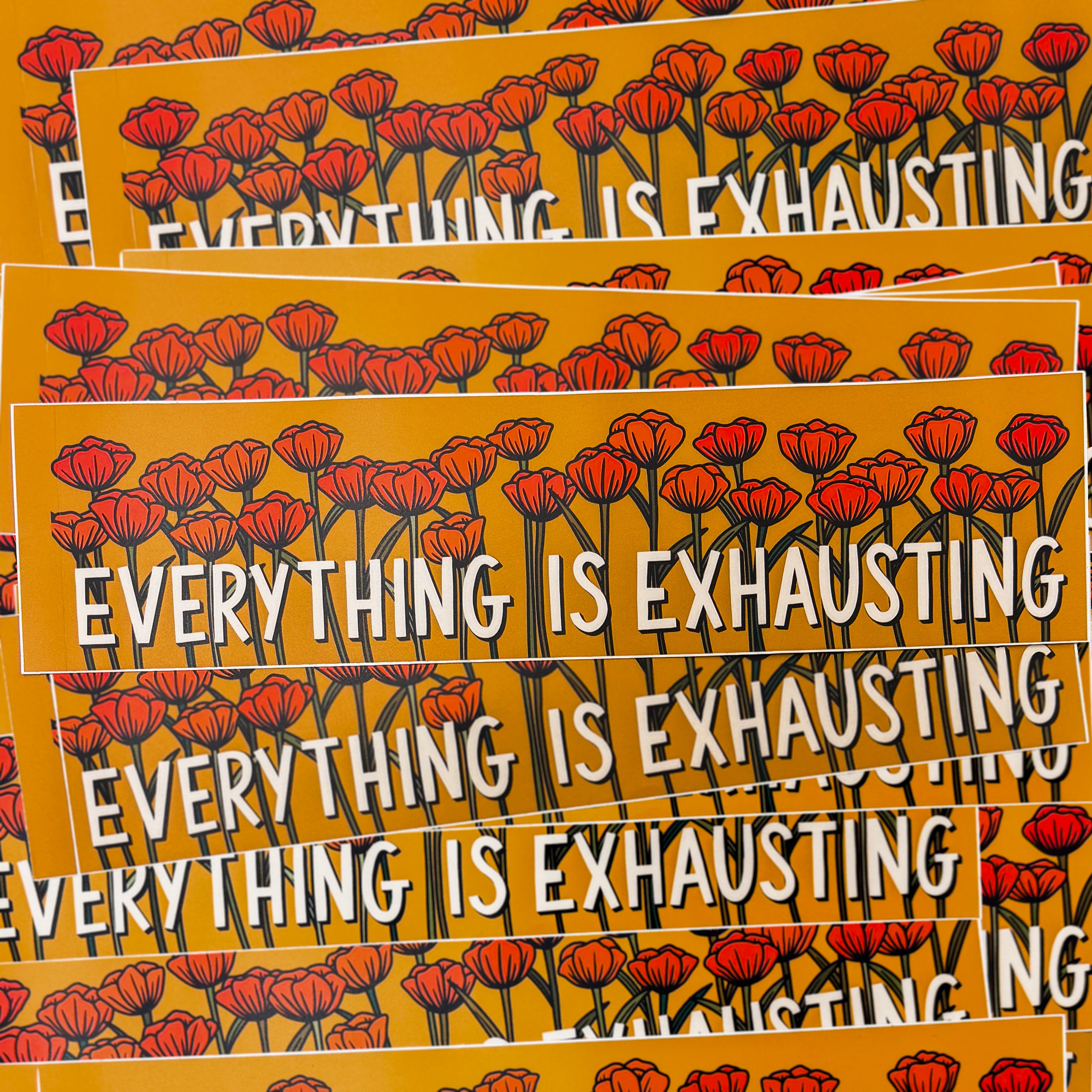 A dark yellow bumper sticker that says "'EVERYTHING IS EXHAUSTING' along the bottom with tons of poppy flowers behind it.