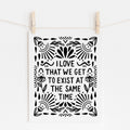 A mockup of an 8x10 art print that says 'I LOVE THAT WE GET TO EXIST AT THE SAME TIME' in black on white paper with floral and whimsy embellishments around it.