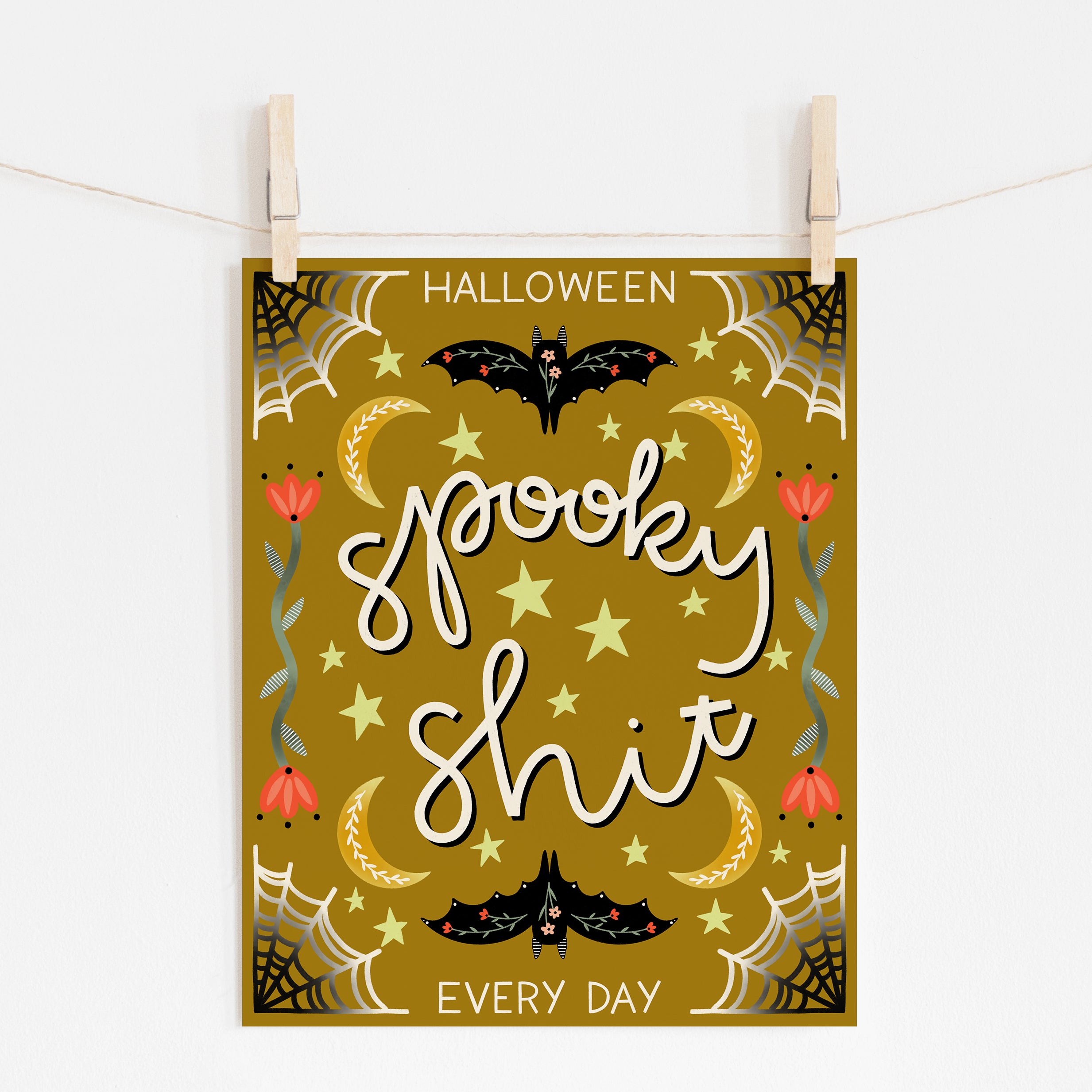 A mockup of an 8x10 Halloween art print with a yellow background that says "spooky shit" in the middle and "HALLOWEEN EVERY DAY" framing the top and bottom. There are spiderwebs, bats, crescent moons, stars, and flowers embellishing it. 