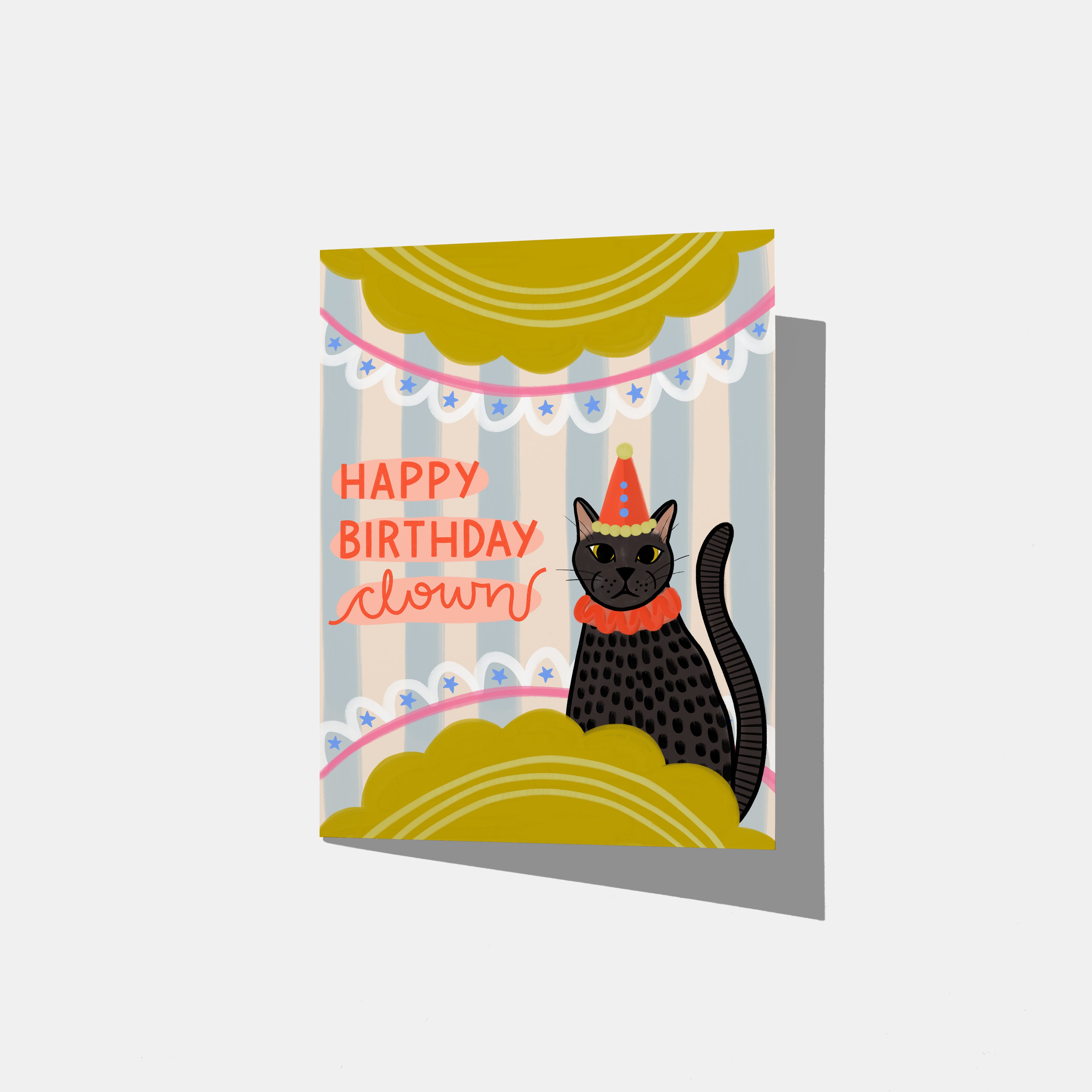 A mockup of a birthday card with a black cat wearing a party hat and 'Happy Birthday Clown' text on a blue striped background with yellow scalloped half circles on the top and bottom with stars and line embellishments.