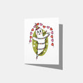 A mockup of a greeting card with a vintage ghost in the middle wearing a party hat, wrapped in Christmas lights, in front of a green oval with white stars. There is a red and pink heart banner above that says 'HAPPY HOLIDAYS'.