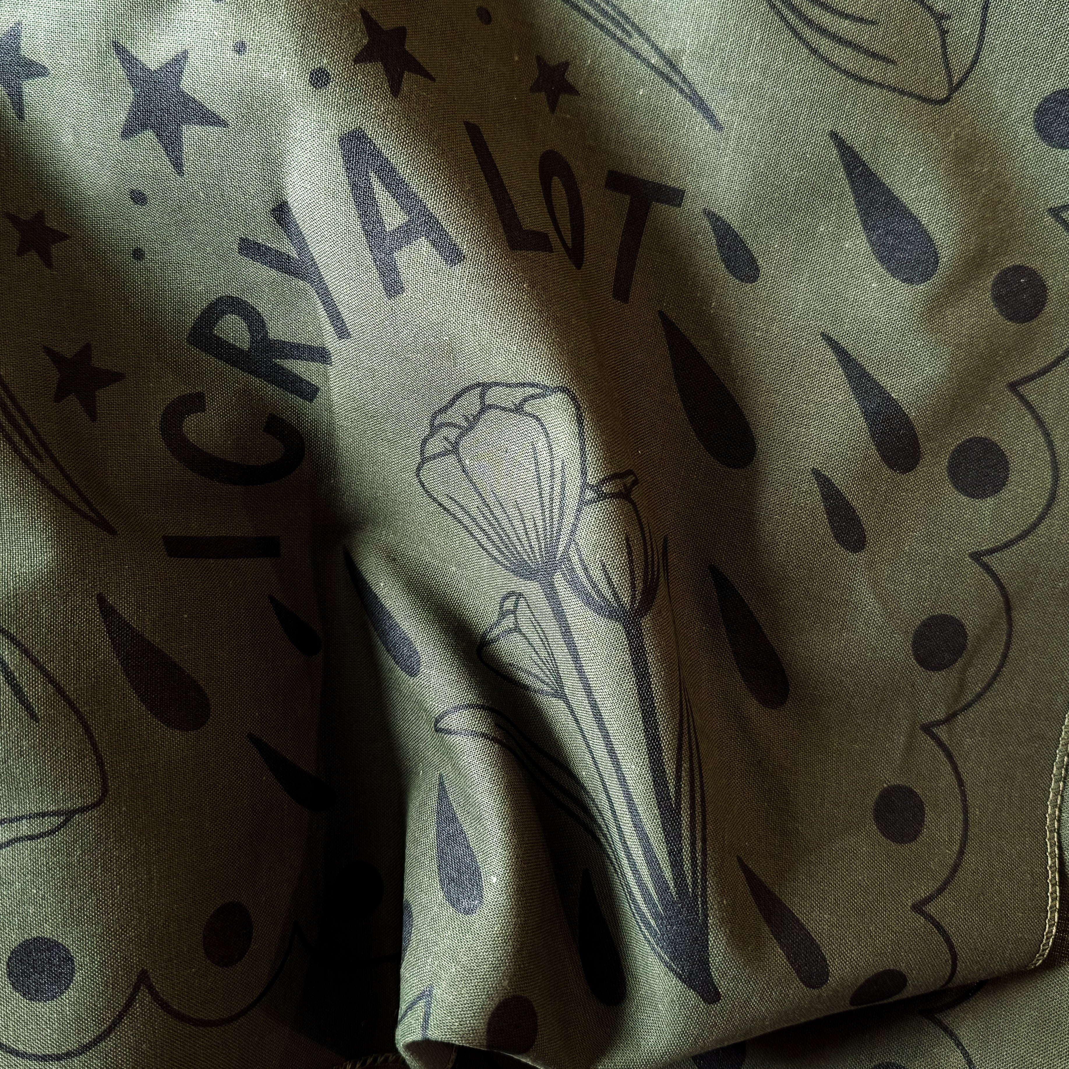Olive green color bandana with black floral patterns and 'I CRY A LOT' text.