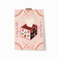 A 5x7 art print that says 'i cry a lot' on each side with a floral tissue box in the middle. Embellished with a pink background, peach details, and tear drops.