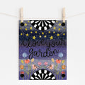 An 8x10 art print that says 'i love your garden' on a background of shades of blue with flowers at the bottom and stars at the top. The top and bottom have black and white half circles and there are buttons in each corner of the print with a needle on string.