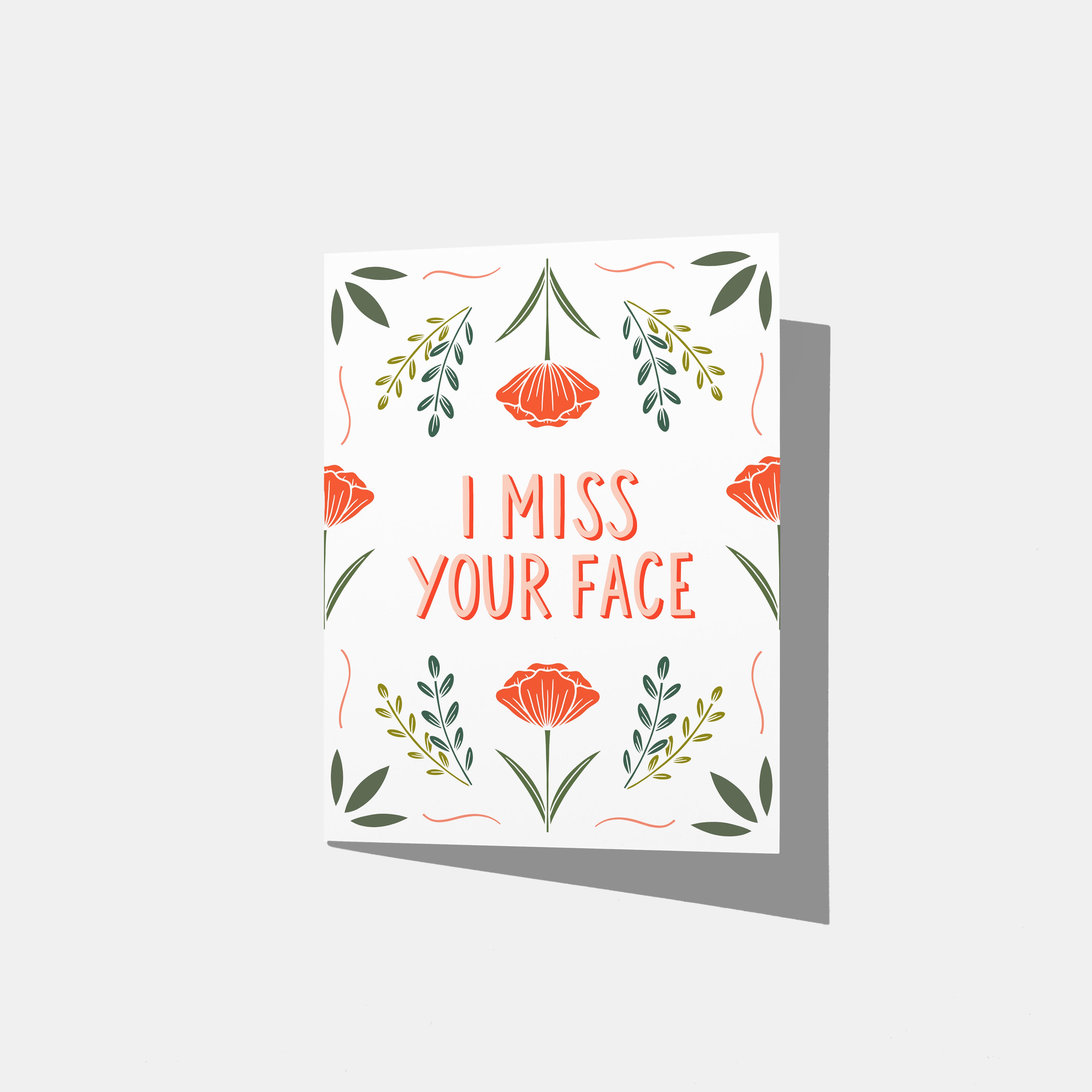 A mockup of a greeting card with floral design and text 'I MISS YOUR FACE' on a white background.