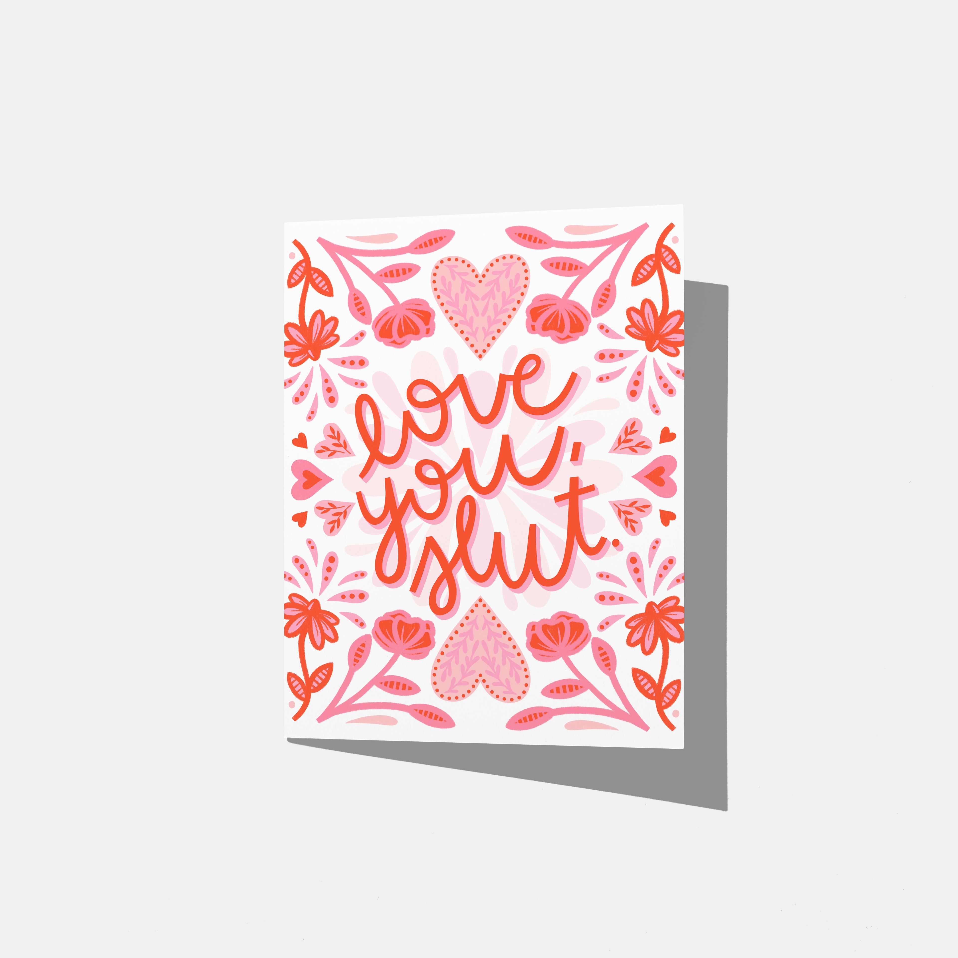 A mockup of a greeting card with 'love you, slut' text surrounded by floral red and pink patterns on a white background.