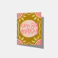 A mockup of a dark yellow greeting card with a pink circle in the middle that says 'i'm so sorry' in pink and red on top. the top corners are pink and say 'oh' and 'no', as the same as the bottom. There are yellow and white embellishments around the card.