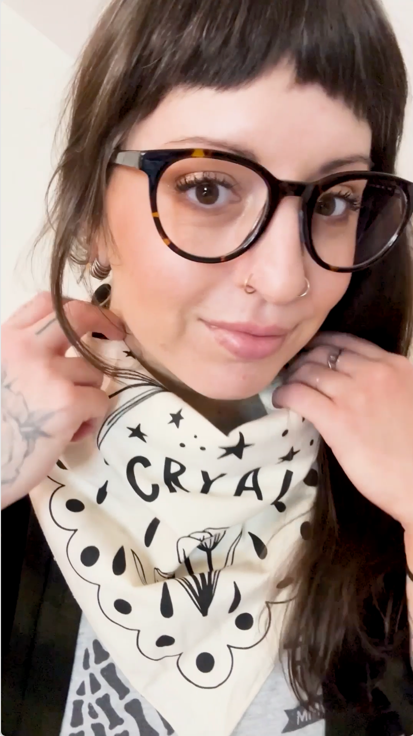 A video of a scarf being worn numerous ways that says ' cry a lot' on it with a floral pattern.