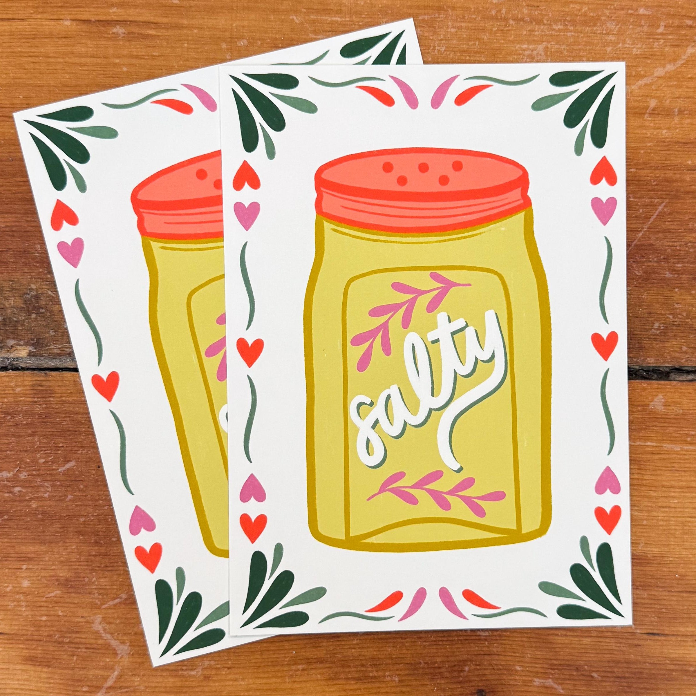 Two 5x7 art prints of a salt shaker that says 'salty' on the front surrounded by a frame of hearts and flourishes.