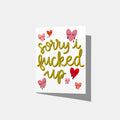 A mockup of a greeting card with green text 'sorry i fucked up' in a yellow/green with red and pink crying heart illustrations on a white background.