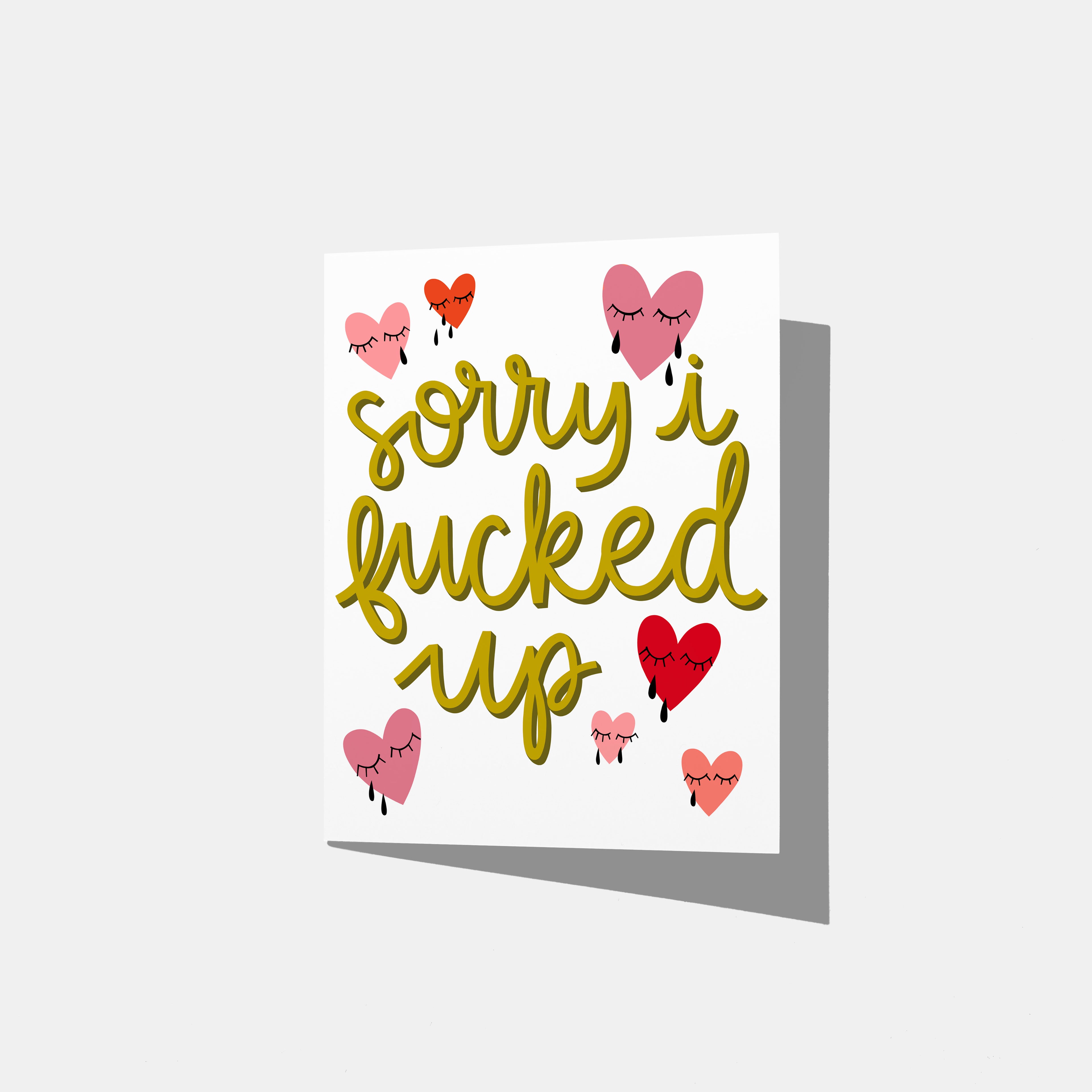 A mockup of a greeting card with green text 'sorry i fucked up' in a yellow/green with red and pink crying heart illustrations on a white background.