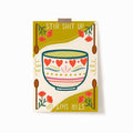 A 5x7 art print with a mixing bowl in the middle, surrounded by flowers and wooden spoons. At the top and bottom, it says 'STIR SHIT UP'.