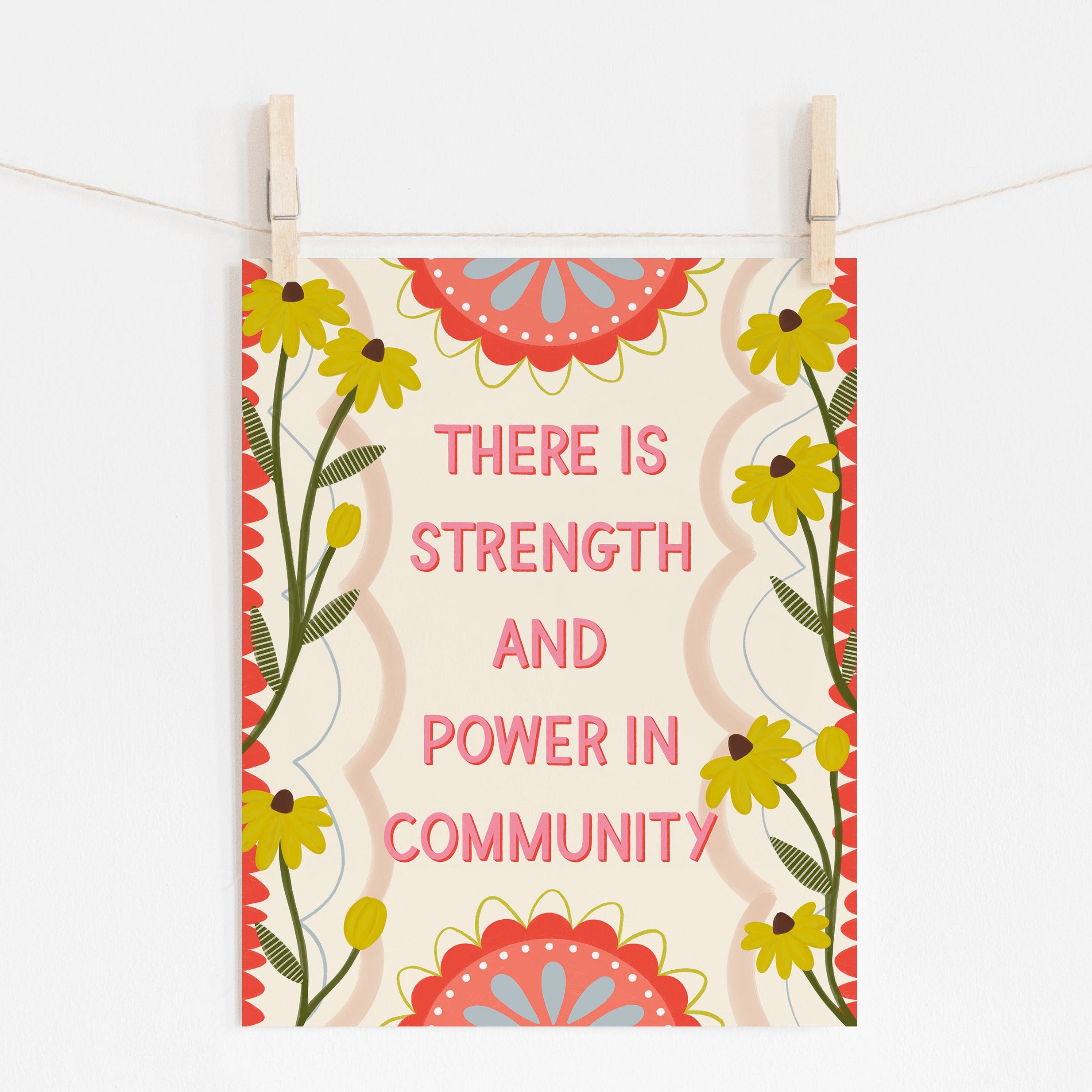 An 8x10 print that says 'THERE IS STRENGTH AND POWER IN COMMUNITY' surrounded by yellow flowers and red embellishments.