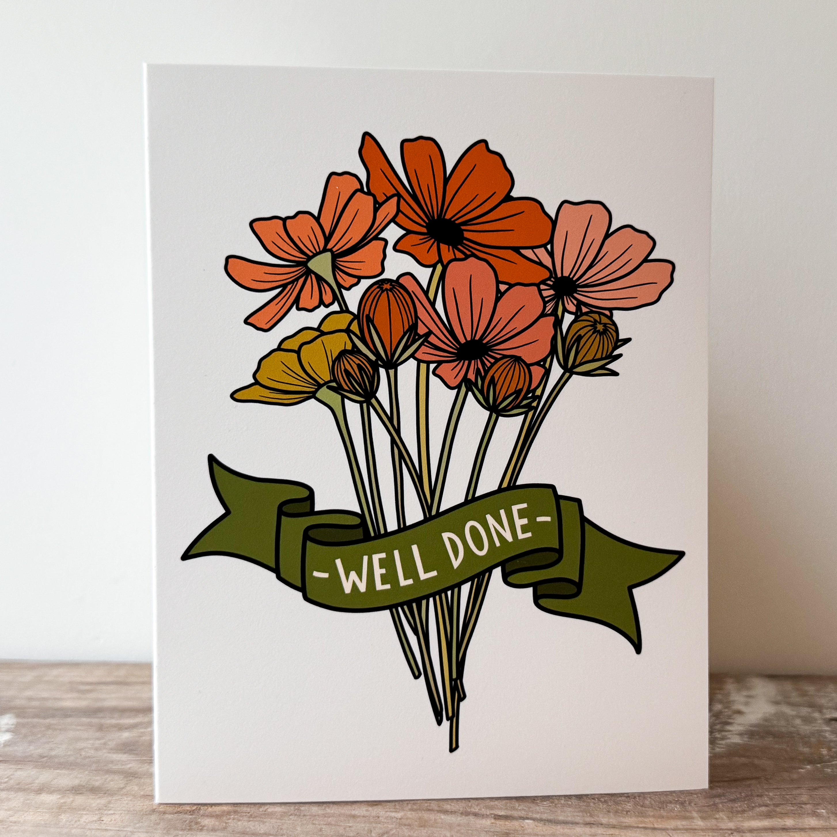 A greeting card of a bouquet of orange, peach, and yellow flowers with a green banner that says '-WELL DONE-'.