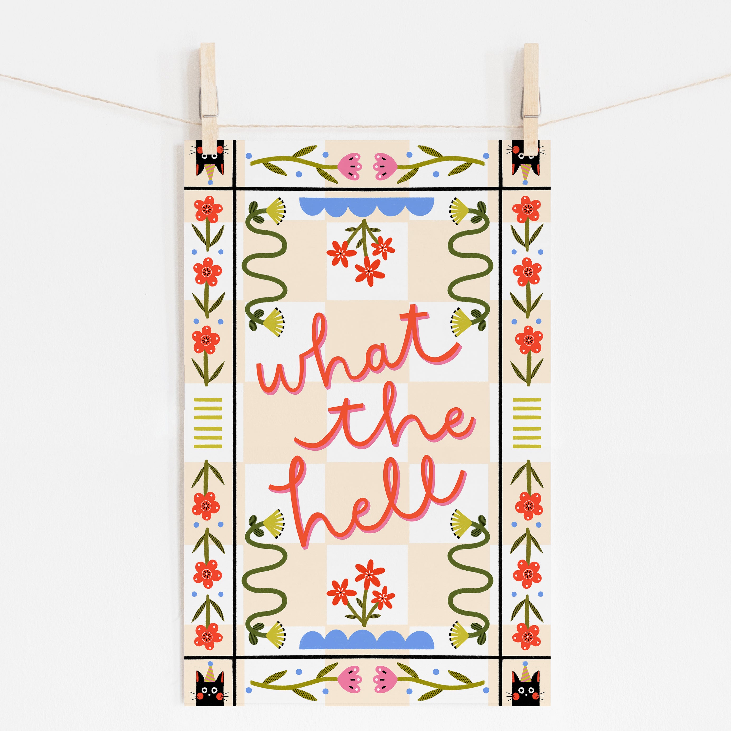 An 11x17 art print with a peach checkered background that says 'what the hell' in the middle, surrounded by folk art style flowers and cats with party hats in the corners.